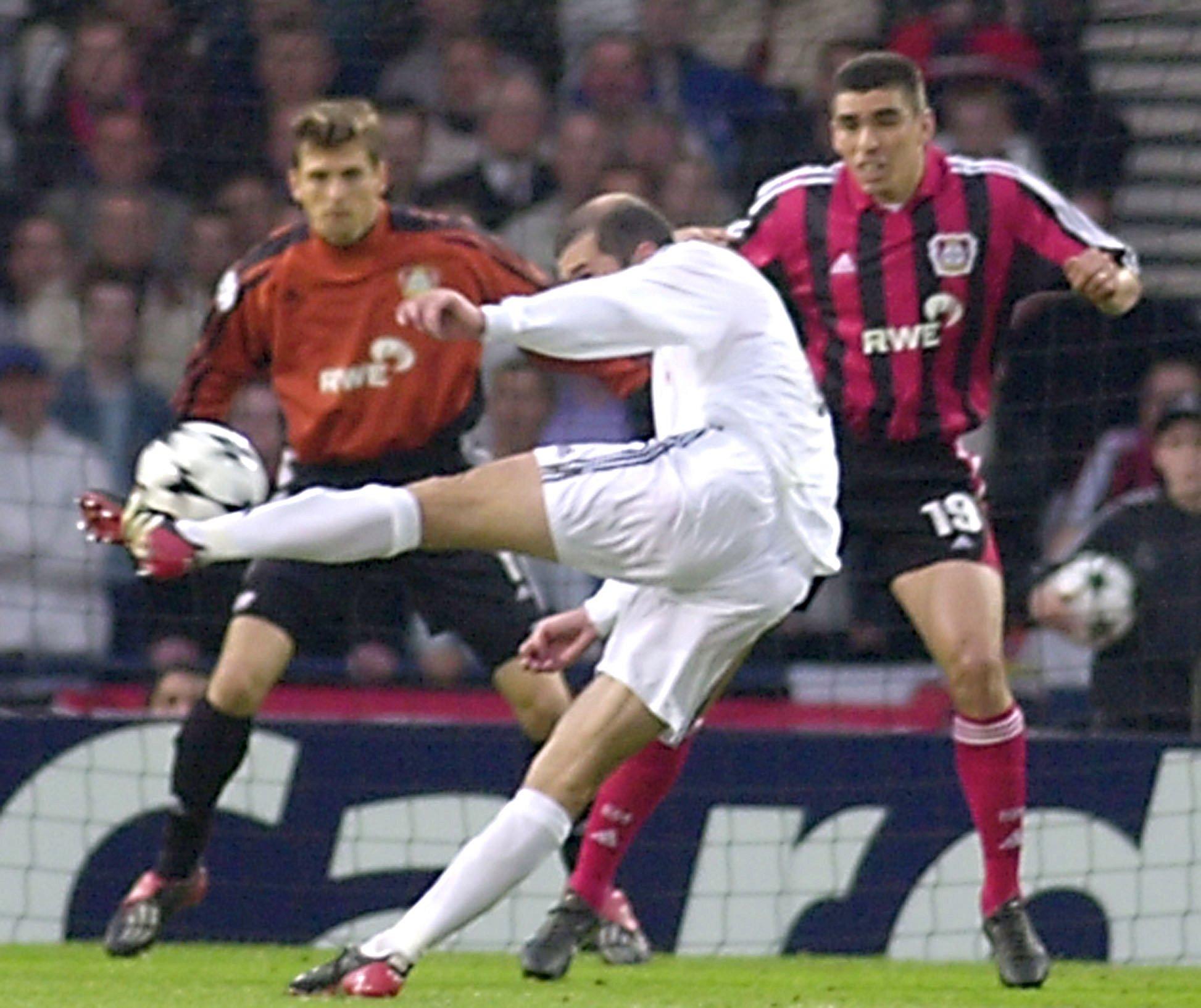 Real Madrid's Zinedine Zidane hits the ball past Bayer Leverkusen's Lucio, right, and goalkeeper Jorg Butt, to score his team's second goal during the UEFA Champions League Final at Hampden Park stadium in Glasgow, Scotland, Wednesday May 15, 2002.(AP Photo/Denis Doyle)