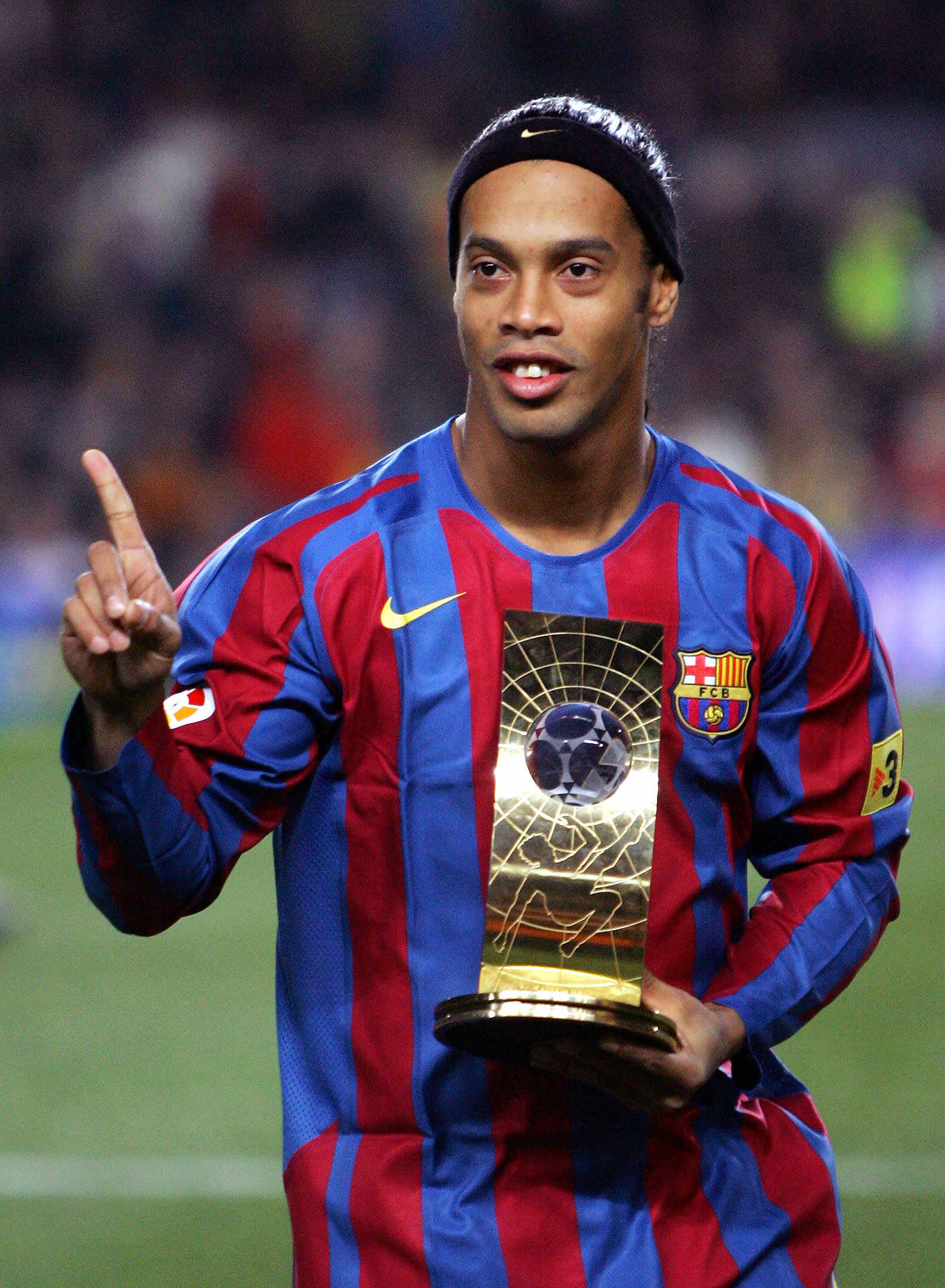 Barcelona's soccer player Ronaldinho of Brazil shows his FIFA world player trophy before their Spanish League soccer match against Celta at Nou Camp Stadium in Barcelona, Spain December 20, 2005. REUTERS/ Albert Gea